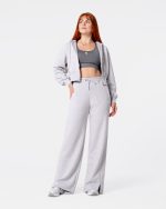 dresy damskie -- spodnie dresowe w kolorze szarym. mają rozciętą nogawkę, wysoki stan i sznurki do regulacji. mają kieszenie.