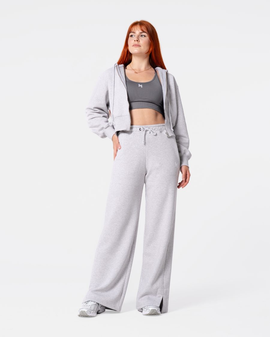 dresy damskie -- spodnie dresowe w kolorze szarym. mają rozciętą nogawkę, wysoki stan i sznurki do regulacji. mają kieszenie.