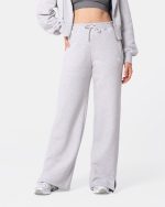 dresy damskie -- spodnie dresowe w kolorze szarym. mają rozciętą nogawkę, wysoki stan i sznurki do regulacji. mają kieszenie.