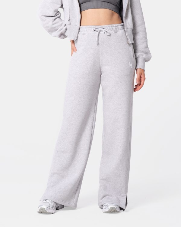 dresy damskie -- spodnie dresowe w kolorze szarym. mają rozciętą nogawkę, wysoki stan i sznurki do regulacji. mają kieszenie.